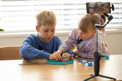 High angle view of siblings playing on table