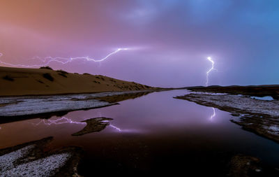Lightning over lake at night