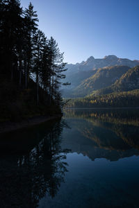 Scenic view of lake by trees against sky