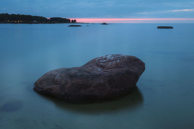 Scenic view of rocks in sea against sky
