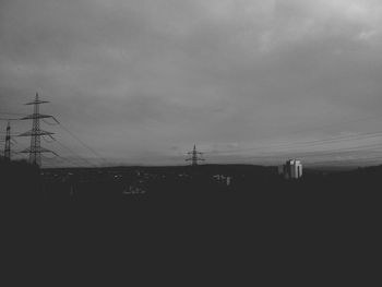 Power lines against cloudy sky