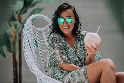 Portrait of smiling young woman sitting outdoors