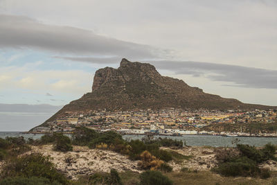 Scenic view of sea by townscape against sky