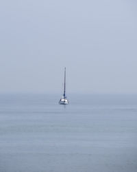 Sailboat sailing on sea against sky