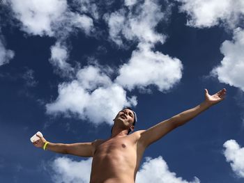 Low angle view of shirtless man standing against sky