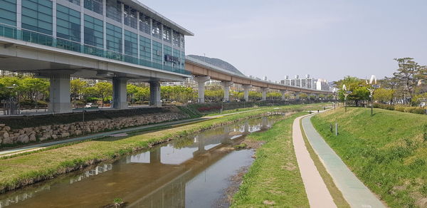 Bridge over canal by buildings against sky