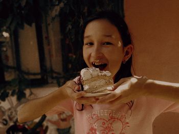 Portrait of a girl holding slice of cake