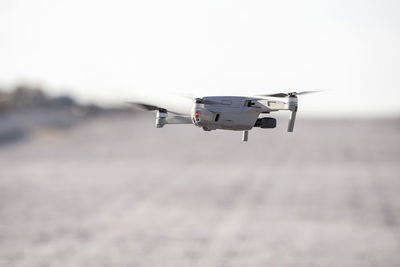 Drone hovering in the sky, landing to the ground.