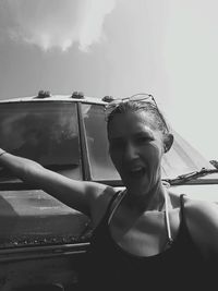 Portrait of smiling young woman against sky