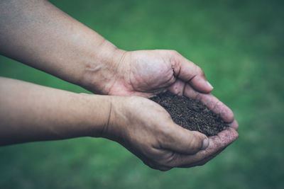 Close-up of man holding soil in hands