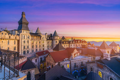 Buildings in city against sky during sunset