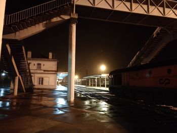 Illuminated bridge over street in city at night