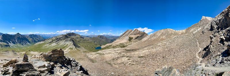 Panoramic view of rocky mountains against blue sky