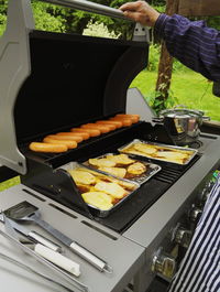 Close-up of person preparing food on barbecue grill