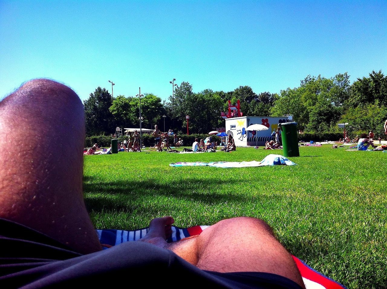 grass, clear sky, field, lifestyles, men, leisure activity, grassy, green color, person, tree, personal perspective, low section, lawn, copy space, relaxation, land vehicle