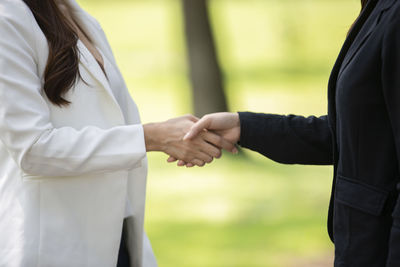 Midsection of couple holding hands