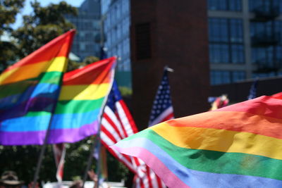 Multi colored flags in city against sky