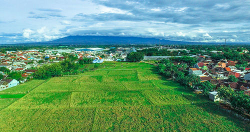 High angle view of green landscape against sky