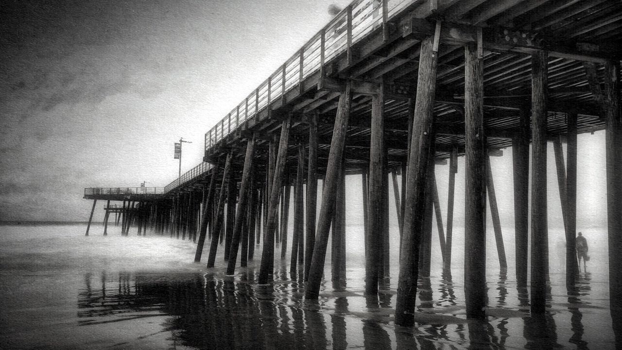 water, built structure, architecture, pier, sea, sky, wood - material, waterfront, reflection, no people, nature, outdoors, tranquility, in a row, day, railing, dusk, clear sky, beach, low angle view