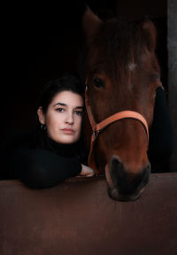 Portrait of beautiful young woman in stable