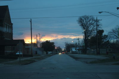 Road in city against sky at sunset