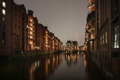 Canal amidst buildings against sky at dusk, wasserschloß hamburg 