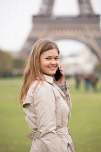 Portrait of smiling woman talking on mobile phone outdoors