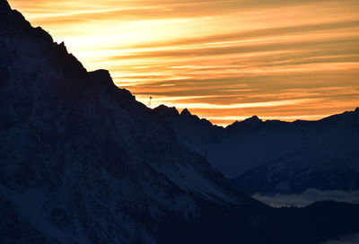 Scenic view of snowcapped mountains against sky during sunset