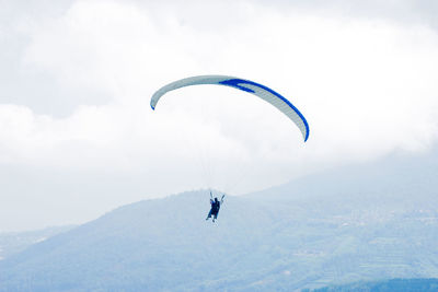 Person paragliding against sky