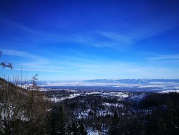 Scenic view of landscape against blue sky during winter