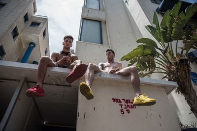 People relaxing in swimming pool against sky