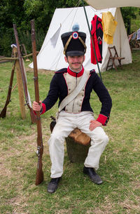 Full length portrait of man sitting on field