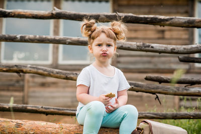 Portrait of boy sitting on wood