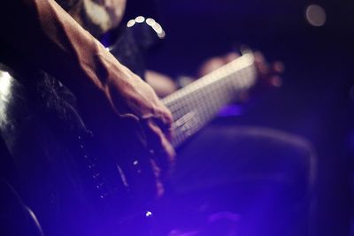 Cropped hand of man playing guitar