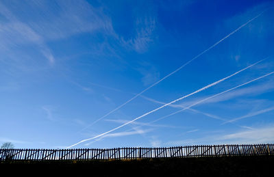 Low angle view of vapor trail against blue sky