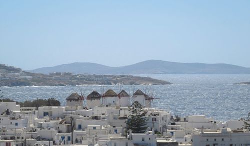 High angle view of townscape by sea against clear sky - windmills of mykonos - view from above