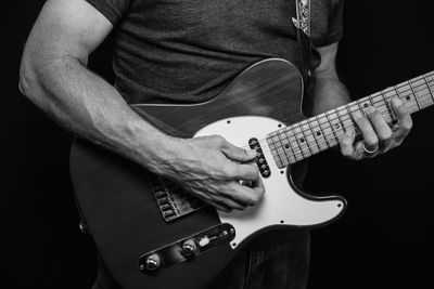 Midsection of man playing guitar