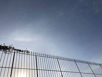 Low angle view of fence against sky