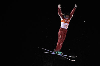 Low section of person jumping against black background