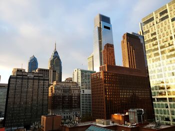 Buildings in city against cloudy sky