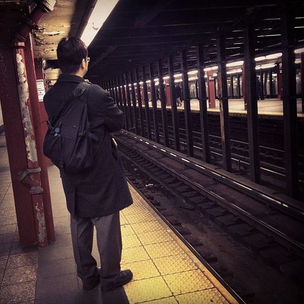 railroad station platform, railroad station, railroad track, public transportation, rail transportation, transportation, indoors, train - vehicle, men, lifestyles, travel, passenger train, passenger, standing, subway station, rear view, walking, train