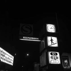 Low angle view of clock on wall at night