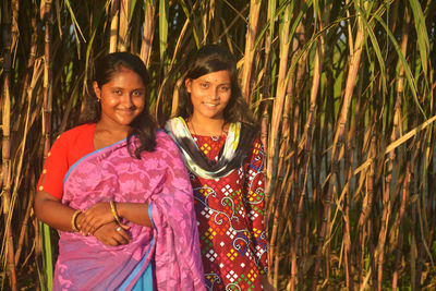 Portrait of smiling girl standing against plants