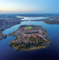 High angle view of city by sea against sky