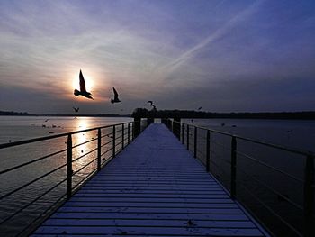 Pier on sea at sunset