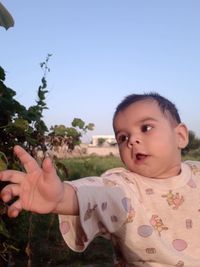 Portrait of cute baby boy against sky