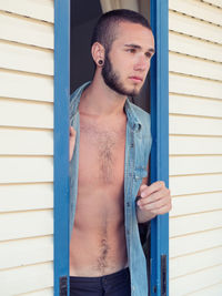 Young man standing amidst sliding door