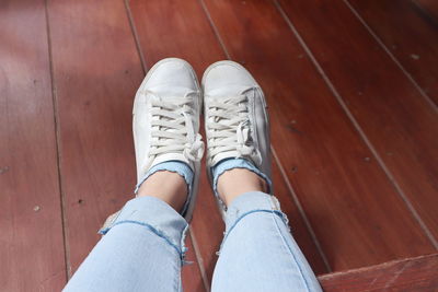 Low section of woman standing on hardwood floor