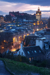 High angle view of illuminated buildings against cloudy sky