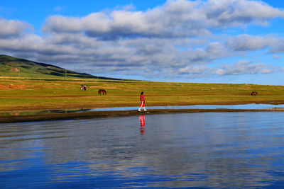 Scenic view of person standing on landscape against sky